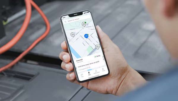 A man using the Ford Pro™ Telematics app on a smartphone