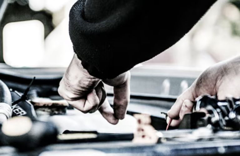 gloved hands installing Motorcraft parts in a Ford vehicle