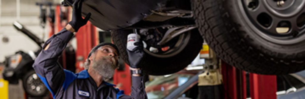 a man performing a Ford oil change at a service center