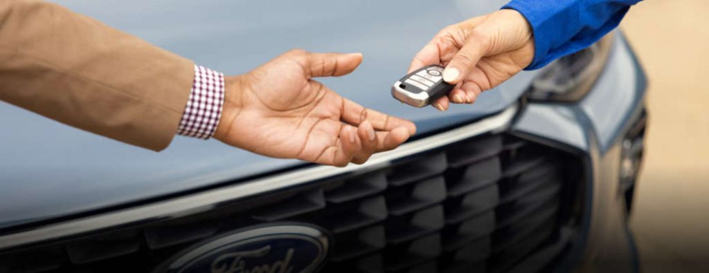 A Ford mobile technician handing the keys back to an owner after a successful mobile repair job.