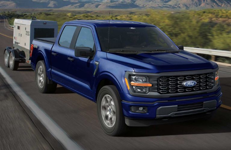 2026 Ford F-150 towing a small trailer on a road