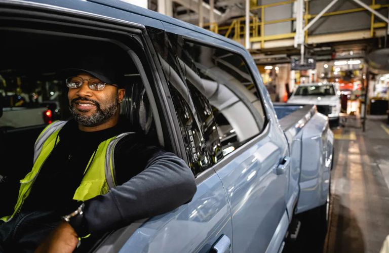 a person in a Ford truck at an assembly plant