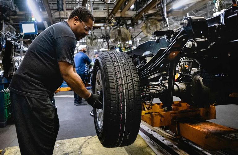 a tire being attached to a Ford truck
