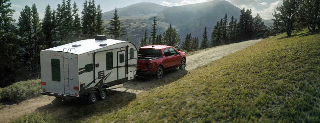 A 2026 Ford Maverick hauling a large trailer on a Georgia mountain backroad.