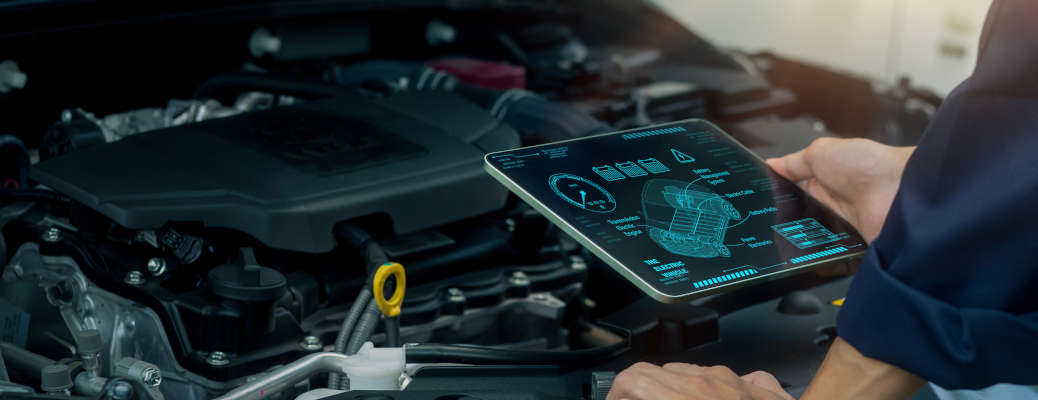 A technician uses a digital tablet to analyze engine data and monitor automotive performance with advanced diagnostic technology. Ideal for smart maintenance, modern vehicle inspection, and automotive engineering content.