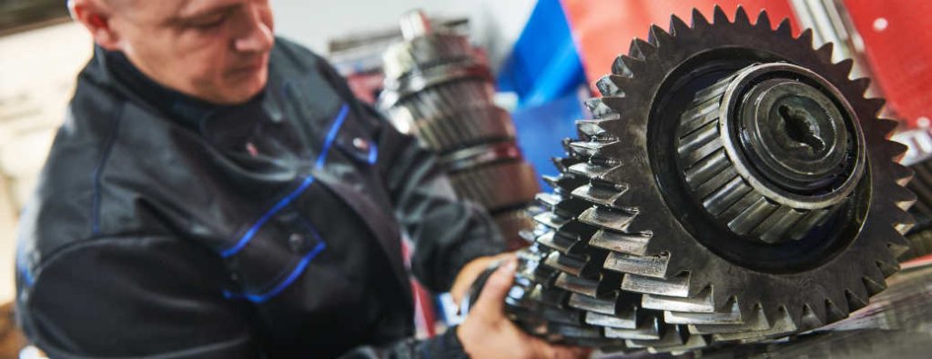 A licensed mechanic working on a truck transmission