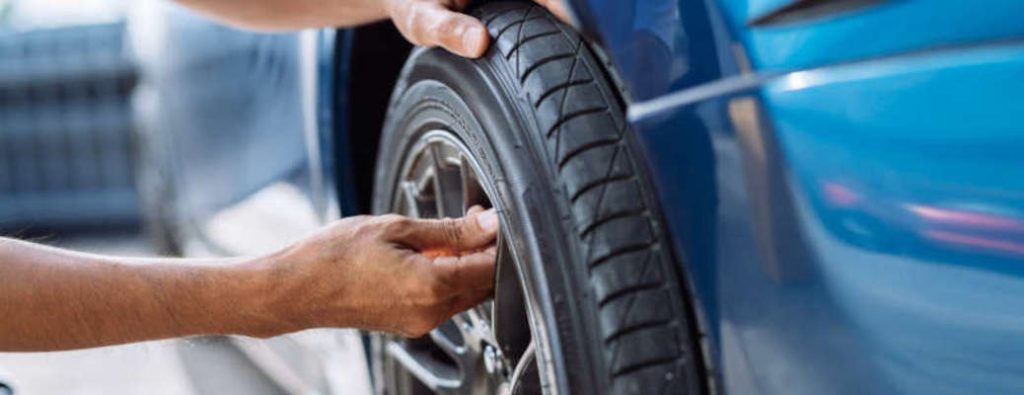 A man inspecting a tire near Winder, GA