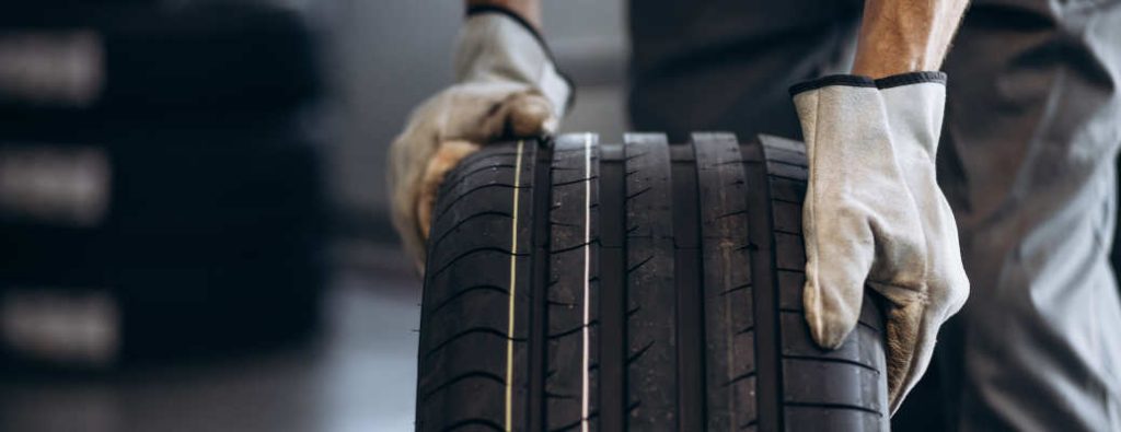 Repairman at car service changing tire