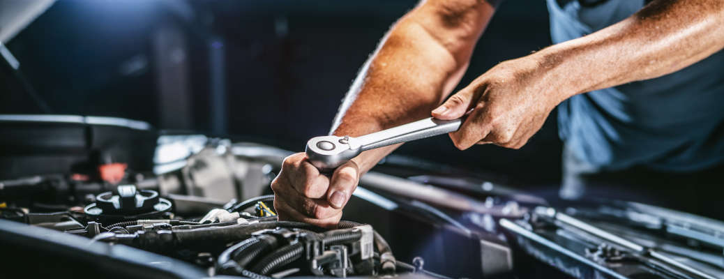 Auto mechanic working in garage. Repair service.
