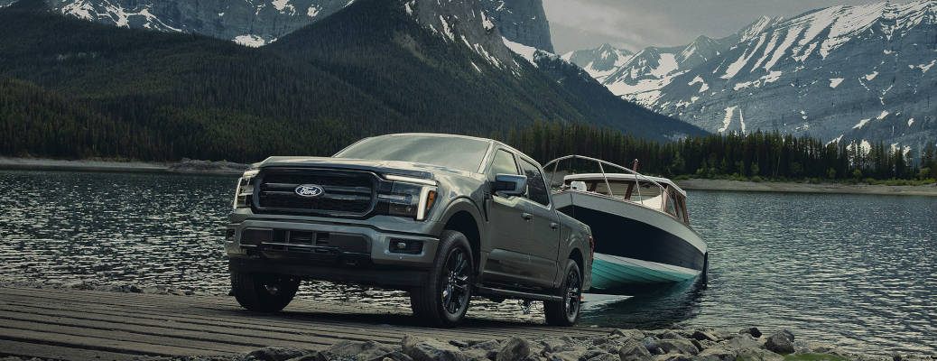 A 2027 Ford F-150 towing a large boar out of a lake