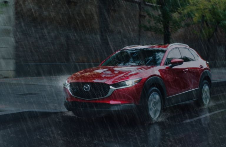 front quarter view of the 2025 Mazda CX-30 in the rain with bright headlights