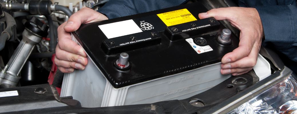 Technician placing car battery