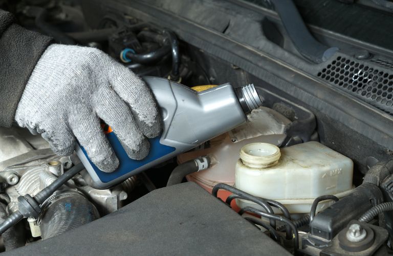 technician topping up brake fluid