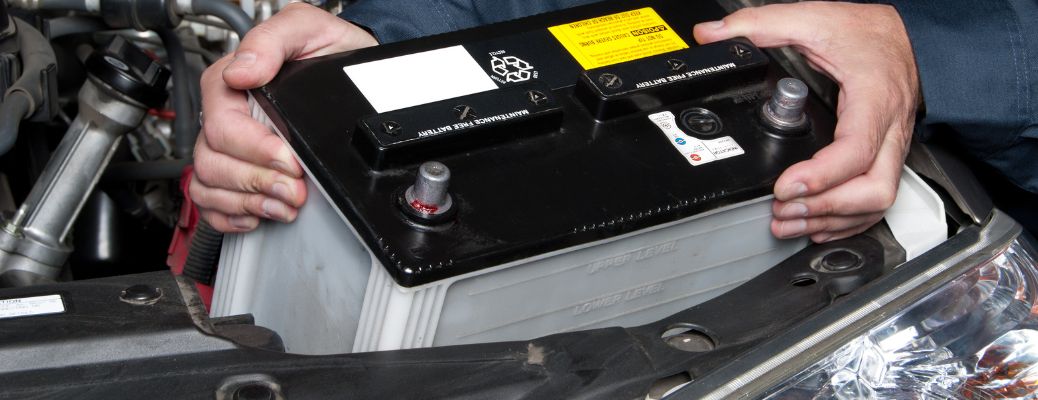 Technician placing car battery after inspection