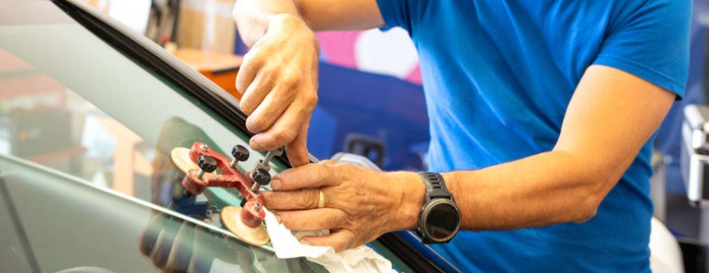 A man repairing a cracked windshield. 