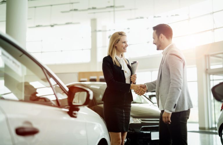 a man and woman talking at a dealership