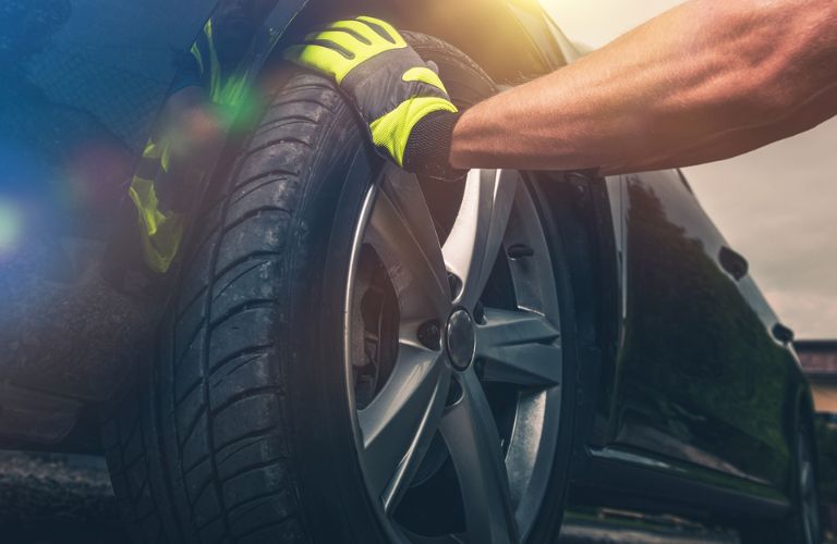 a technician inspecting the tire of a car