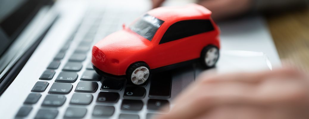 a toy car on laptop's keyboard