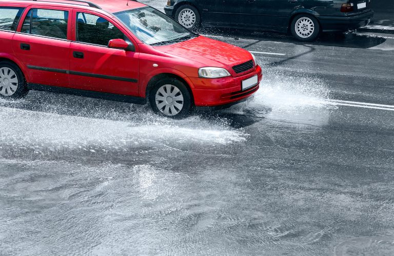 side view of a car being driven in rain