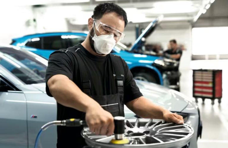 a technician inspecting the wheel of a car