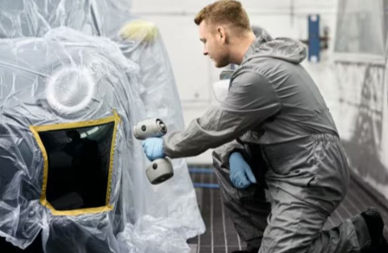 a technician working on a car in a collision center