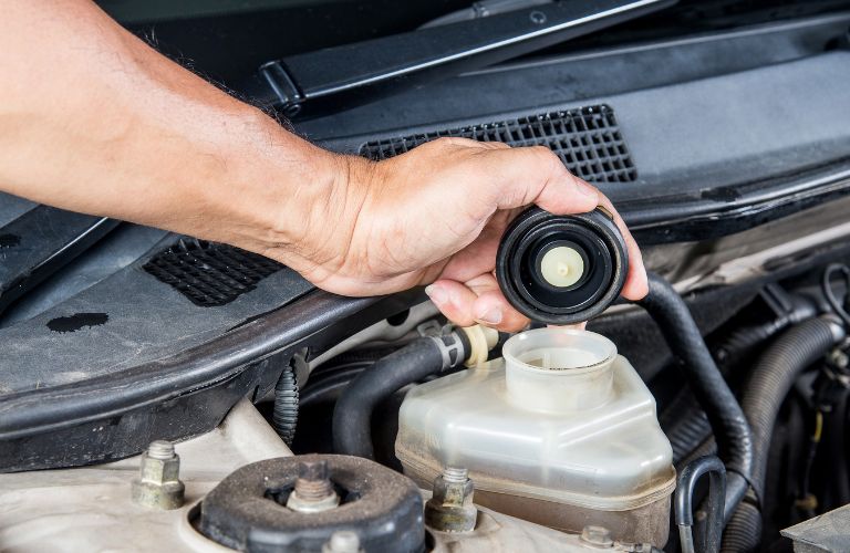 technician pouring fresh fluid in a car