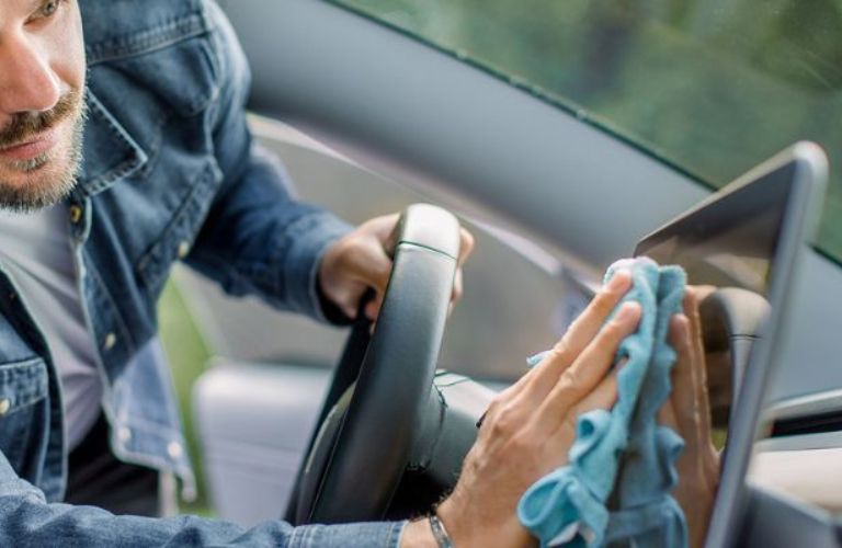 close up of a technician wiping the infotainment of a car