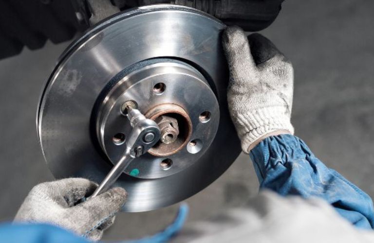 Technician checking brake plate of a vehicle