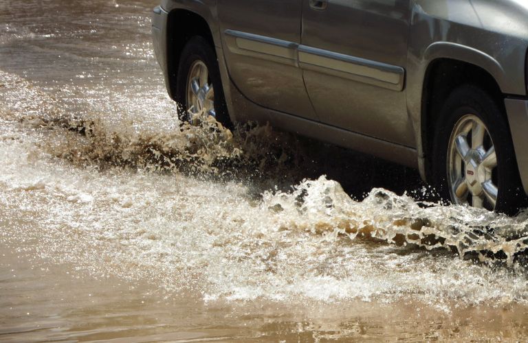 Car moving in water filled road