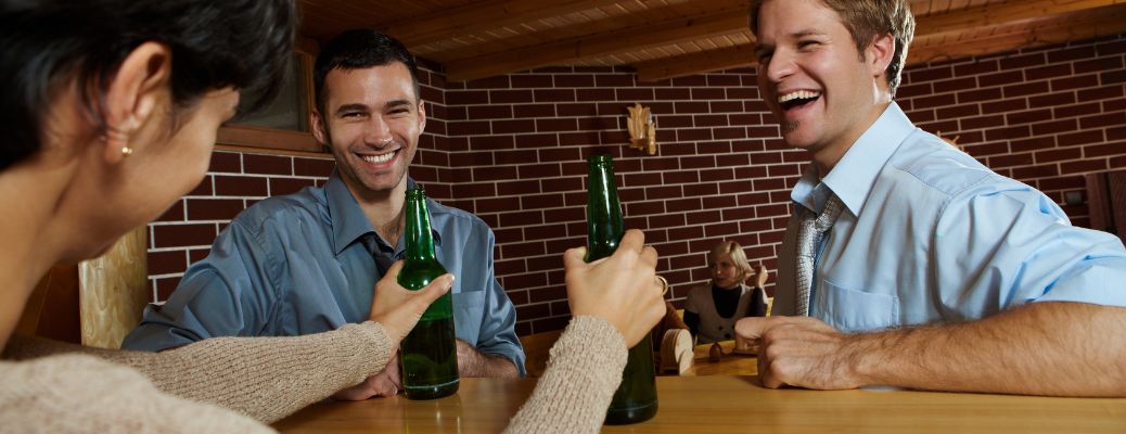 people sitting together with beer bottles