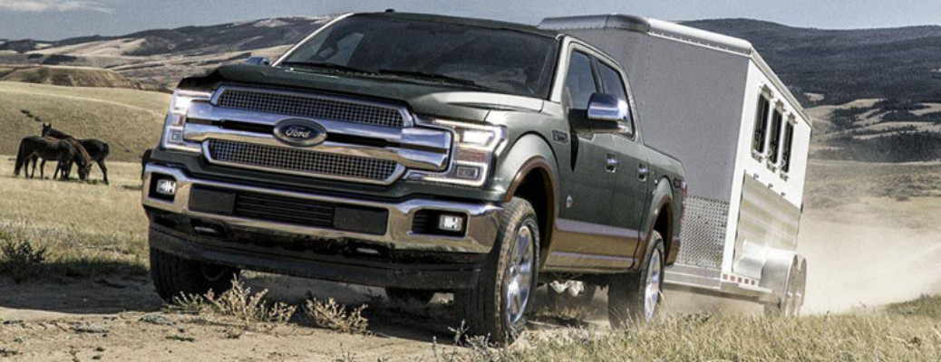 2018 Ford F-150 towing a trailer by horses
