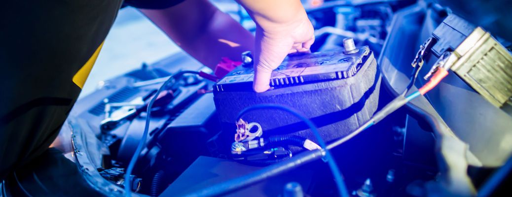 two hands on a vehicle car battery