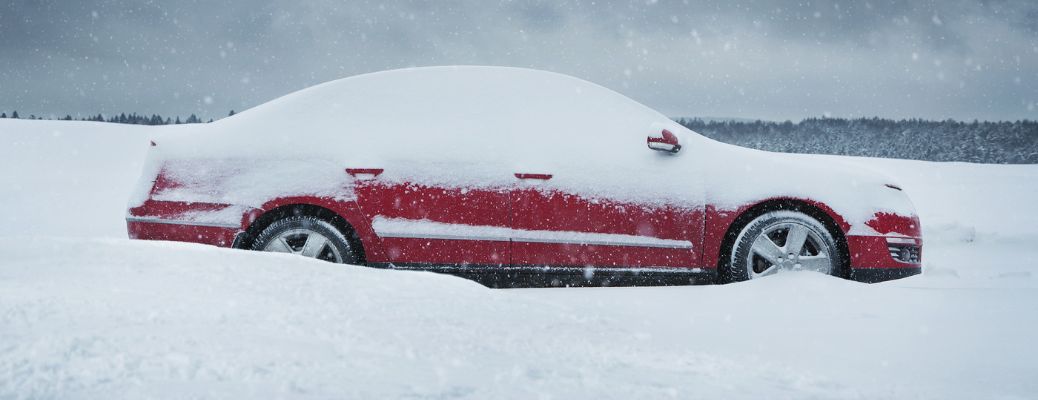 a red car stuck in deep snow