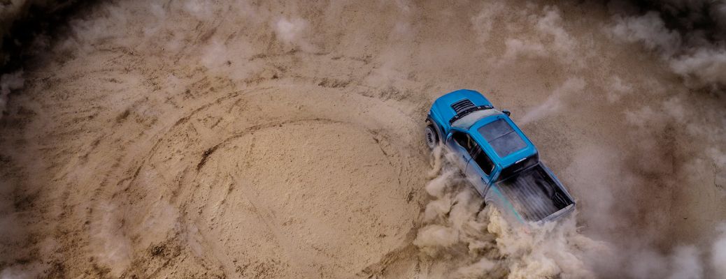 2019 Ford F-150 Raptor driving in a sandy circle