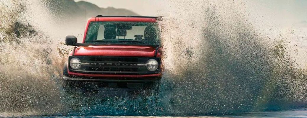 2021 Ford Bronco driving through mud front view
