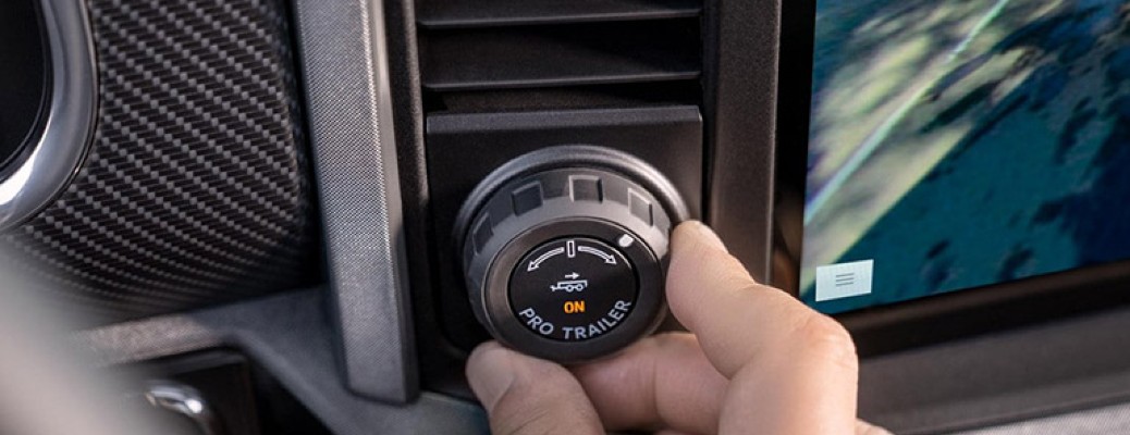 Two fingers pinching a trailer guidance knob in the 2021 Ford F-150 next to the display screen