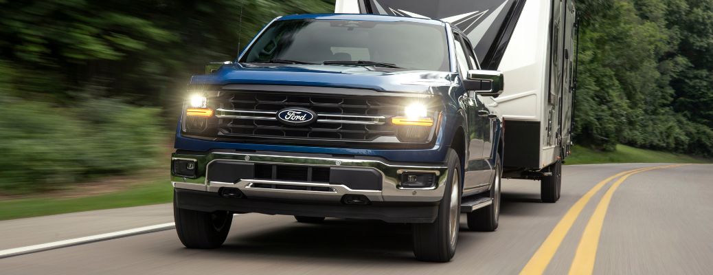 2024 Ford F-150 with headlights on towing a trailer