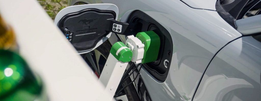 Ford robot charging arm plugged into a car