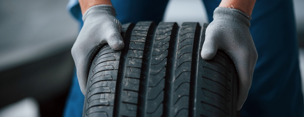 a tire held between two gloved hands