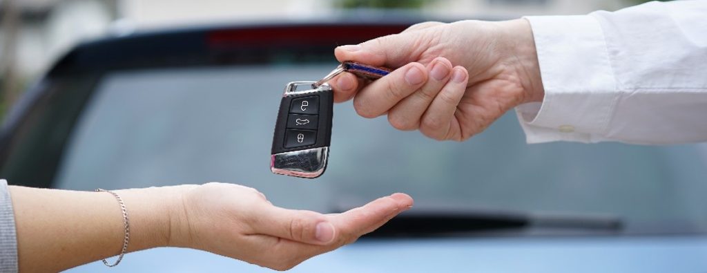 Two hands passing a set of car keys between them