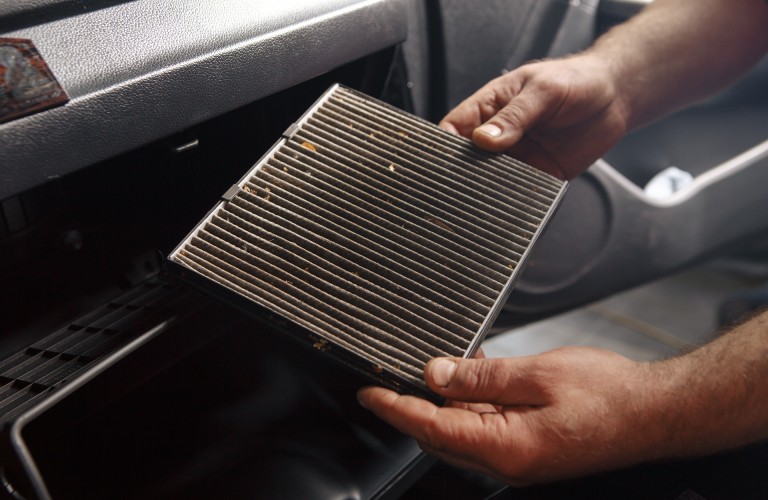 two hands holding a car air filter