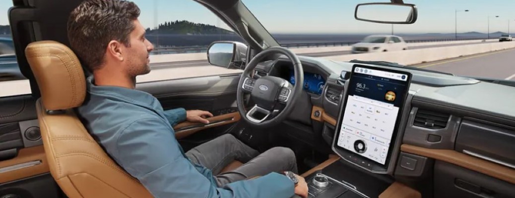 A man driving hands-free in a Ford vehicle on a highway