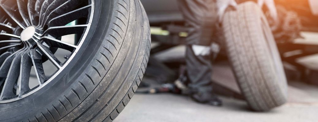 two tires by a person working on a car