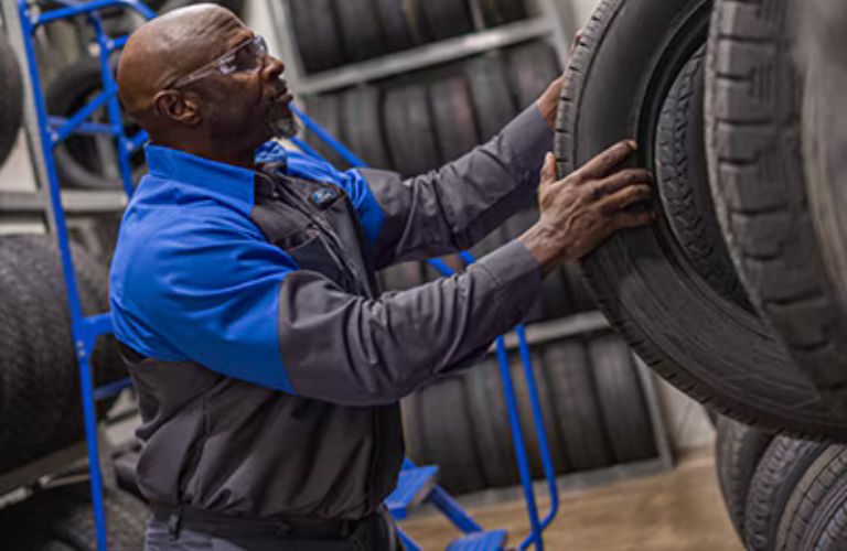 a man getting a tire to get a Ford car ready for fall
