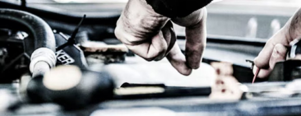 two gloved hands working on a vehicle