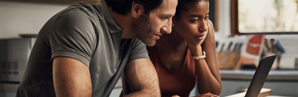 Two people looking at a computer together