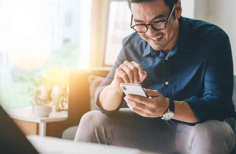 a person checking his phone with a smile