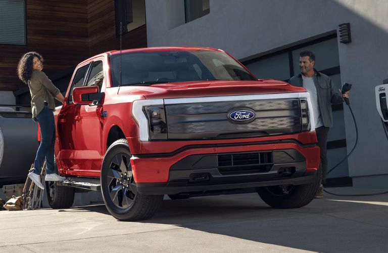 Ford F-150 Lightning truck with people at a house