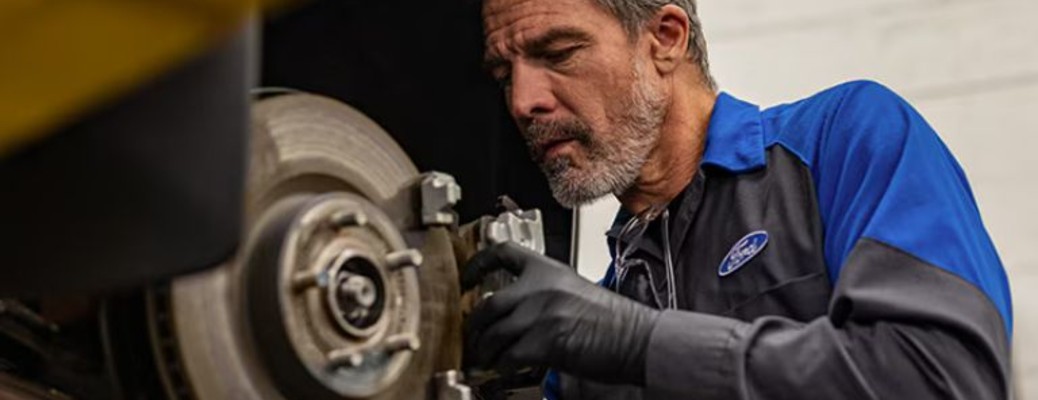 a man checking the brakes of a car