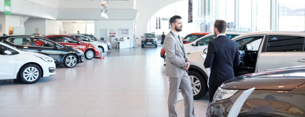 two people talking at a car dealership